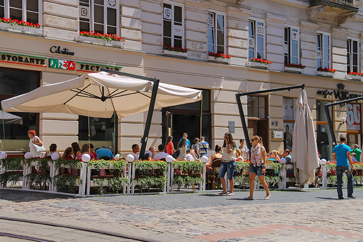 People resting in outdoor cafe in historic city centre